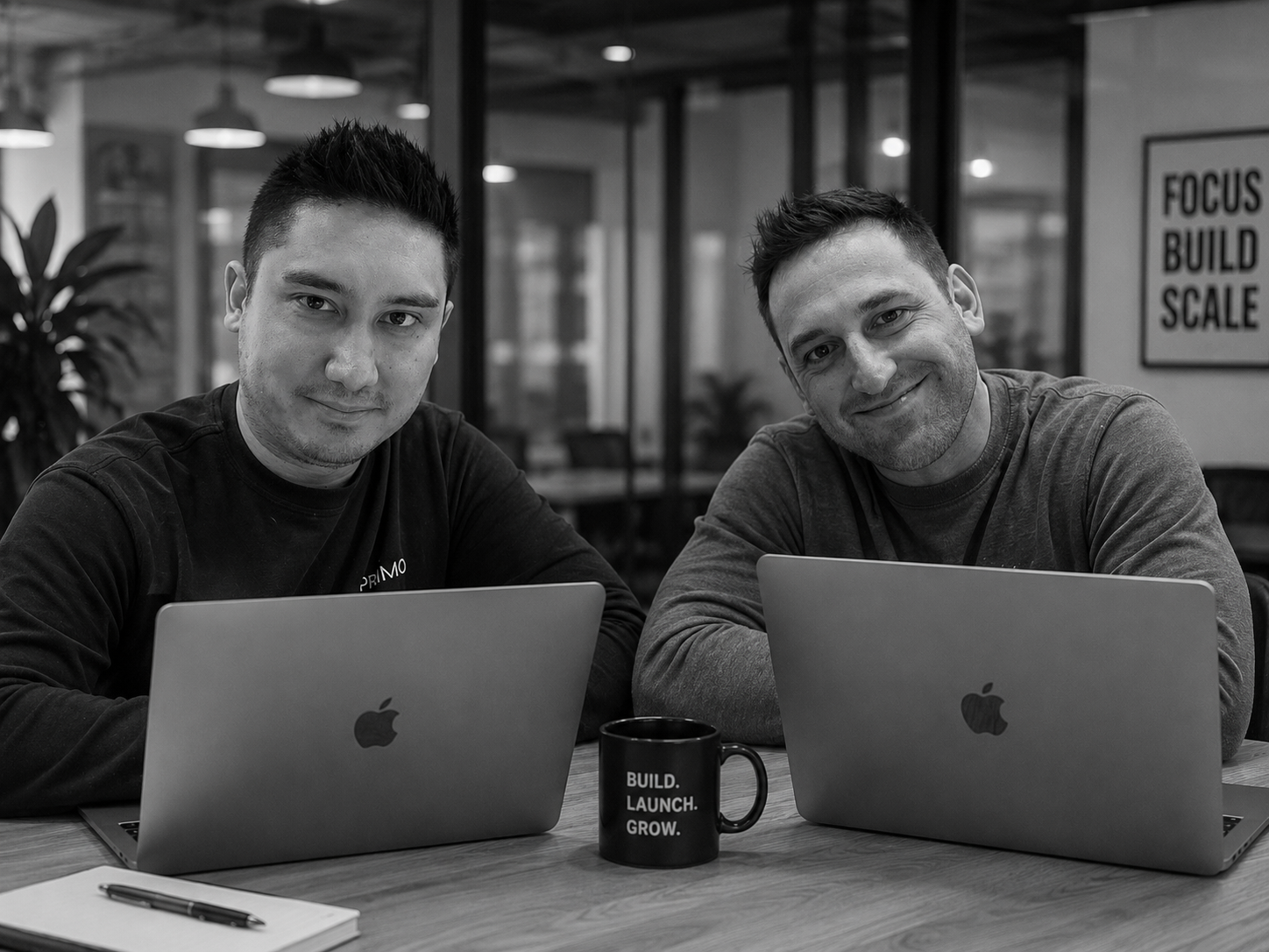 Pete and Jeff, co-founders of Assembled Systems, working together at their laptops in a modern office